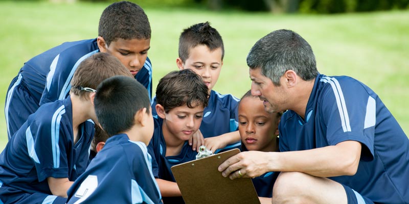 Football coach working with kids